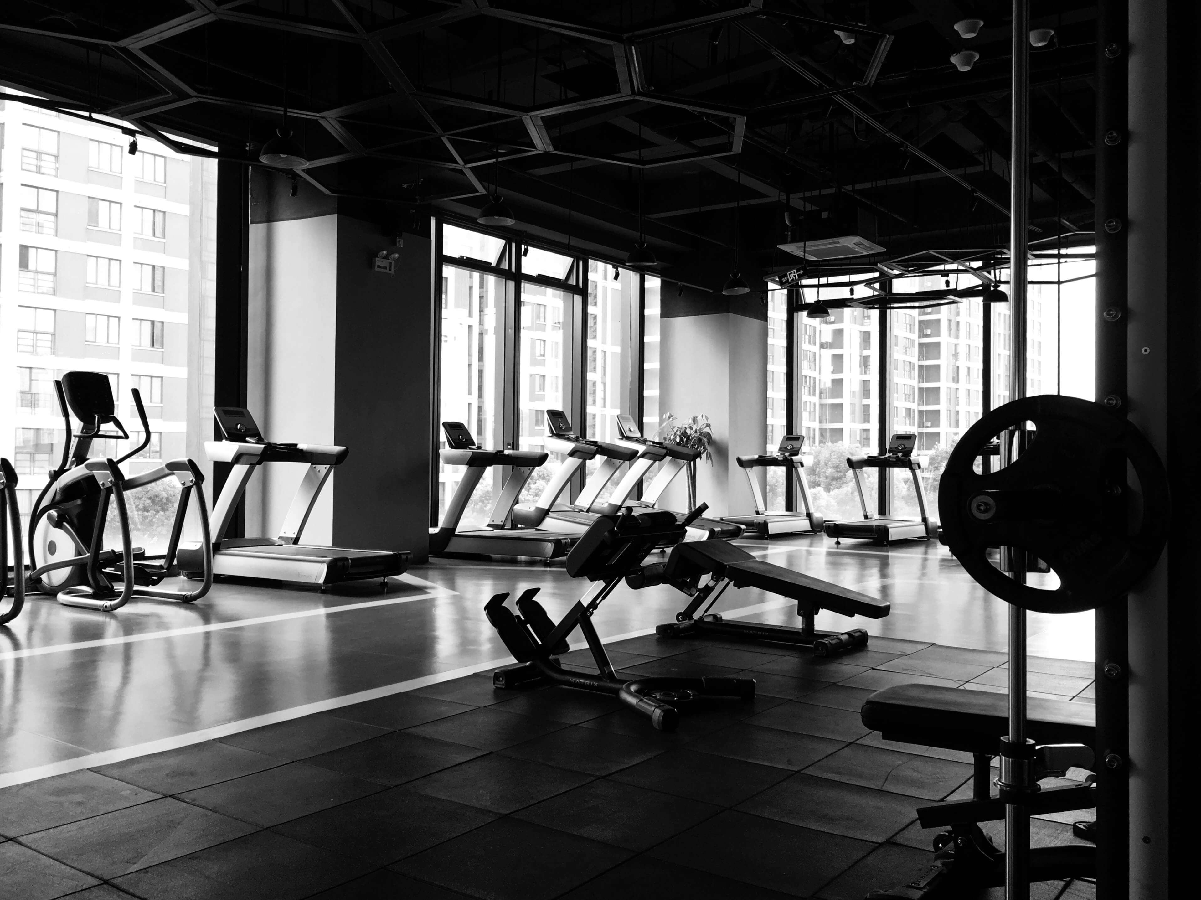 Une salle de sport avec des tapis de course